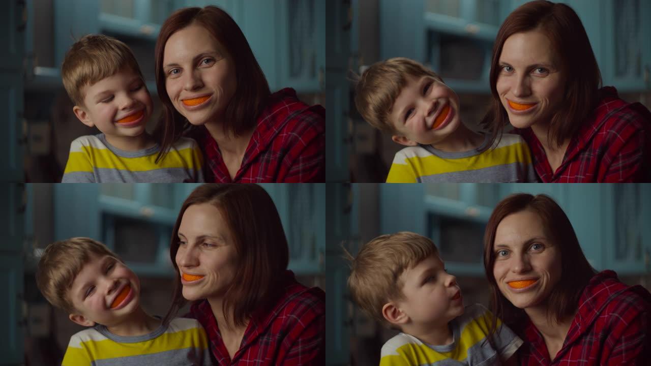 有趣的家庭在家里嘴里玩橘子皮。微笑的女人和学龄前儿童，嘴里有橙色水果。橙色的微笑。