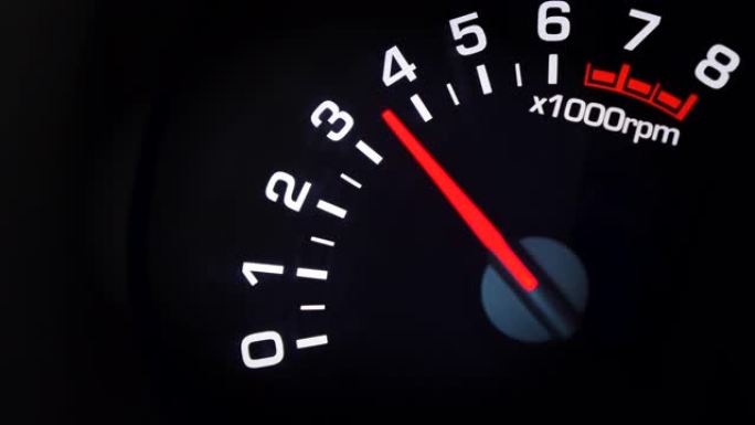 汽车转速表和其上的移动指针指示变化的发动机RPM。汽车仪表板。带有指示灯的仪表板详细信息。汽车仪表板