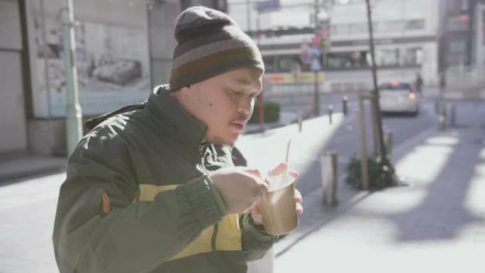 亚洲男子在日本东京捧着一碗汤吃日本传统料理