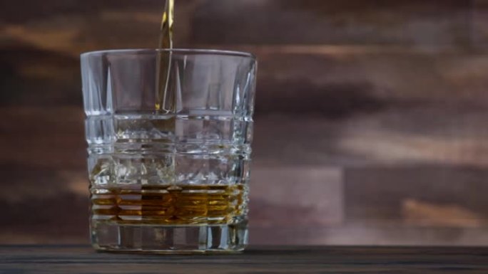倒入玻璃中的金色威士忌或波旁威士忌。在木桌上两杯威士忌或白兰地