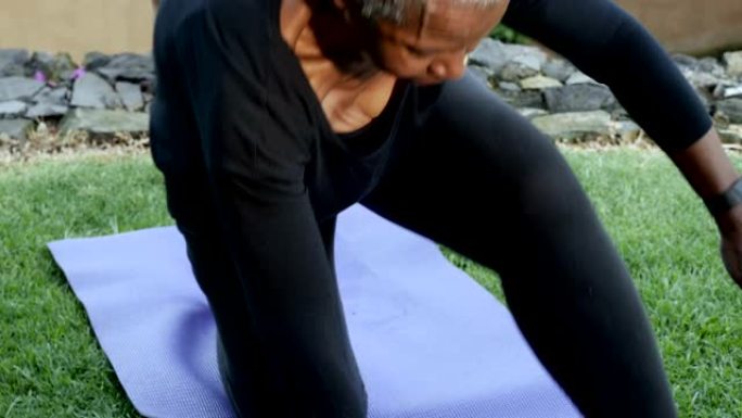 活跃的非洲裔美国高级女性在运动垫上练习瑜伽