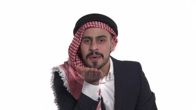 一个年轻的阿拉伯男人折叠嘴唇并握着手掌发送空气之吻的特写镜头。肢体语言