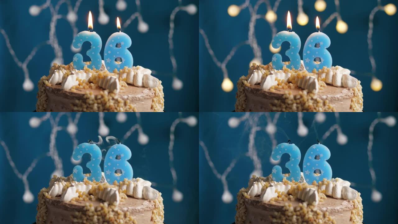 蓝色背景上有36号蜡烛的生日蛋糕。蜡烛吹灭了。慢动作和特写视图