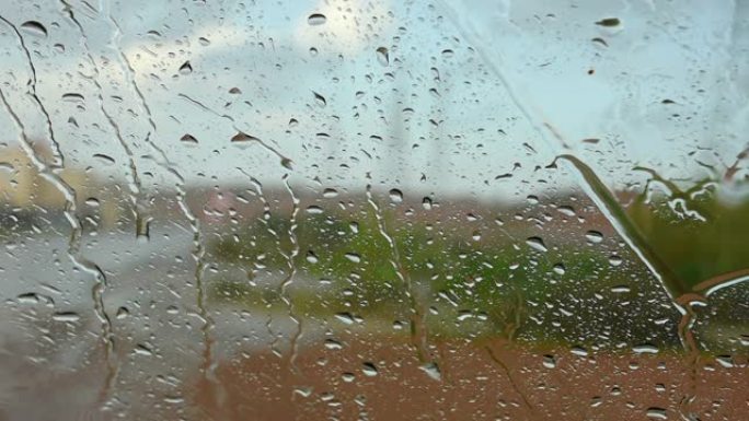 在雷暴期间，水雨滴落在窗户上，形成纹理图案和概念背景。