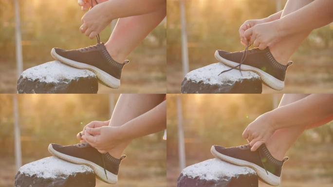 亚洲女人系鞋准备在早晨的阳光下在旅途中锻炼。健身与健康生活方式，开始锻炼理念