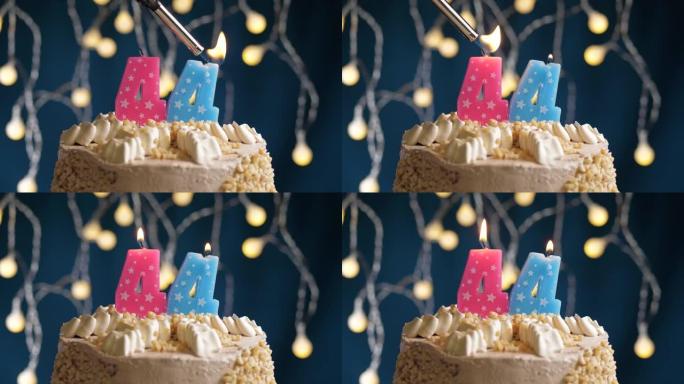 蓝色背景上有44号粉色蜡烛的生日蛋糕。蜡烛着火了。慢动作和特写视图