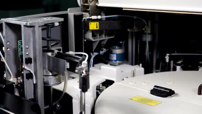 生物科学实验室人体生物材料医用自动机器人分析仪的近距离应用。机械导管缓慢移动以进行测试分析。科学的电