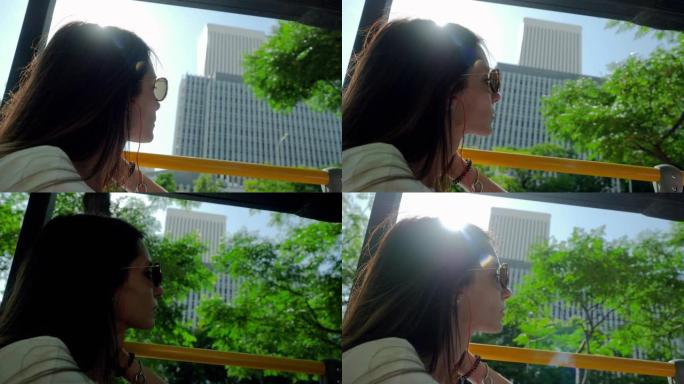 在夏天阳光明媚的日子里，年轻美丽的女人在乘坐旅游巴士环游城市时看着马德里的风景。西班牙。4K