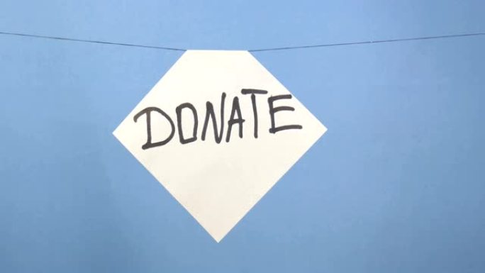 燃烧和吸烟的白色纸，蓝色背景上有黑色题词 “捐赠”