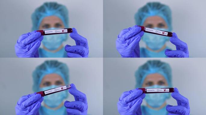 医生，一个女人，手里拿着一个冠状病毒测试阳性的试管，看着它。