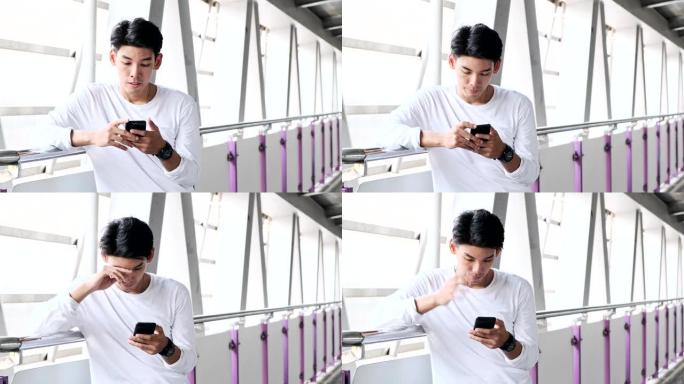 街头小鬼在立交桥里用手机。穿着白衬衫的亚洲男人。