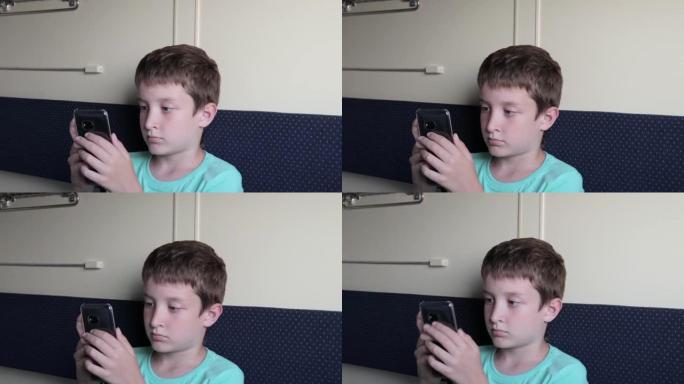 一个青春期男孩在坐火车，旅行和旅行时在智能手机上玩游戏