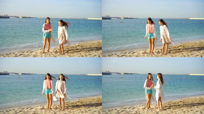 小快乐有趣的女孩在热带海滩一起玩有很多乐趣。