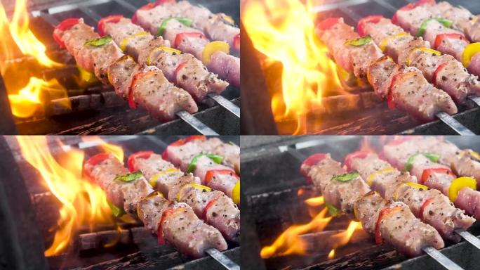 肉串上多汁，嫩的烤肉串。将肉和胡椒刺穿并在煤上油炸。肉上撒上胡椒和香料。在明火上烹饪。慢动作特写。