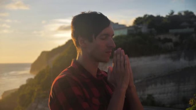 一个男人在日落时祈祷的剪影宗教概念。剪影人关闭。