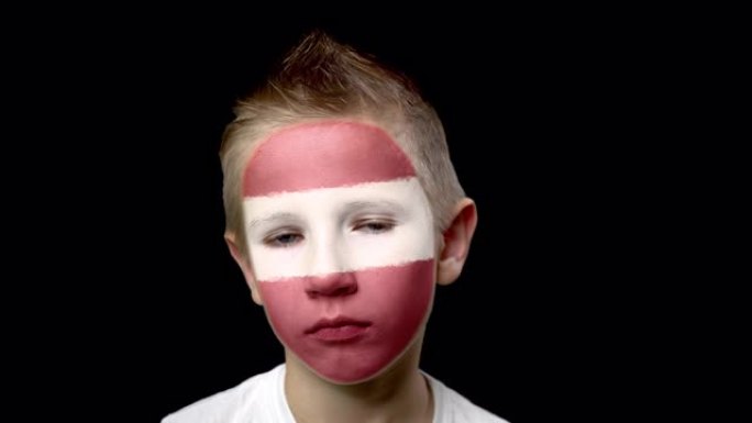 可怜的拉脱维亚足球队球迷。脸上涂着民族色彩的孩子。