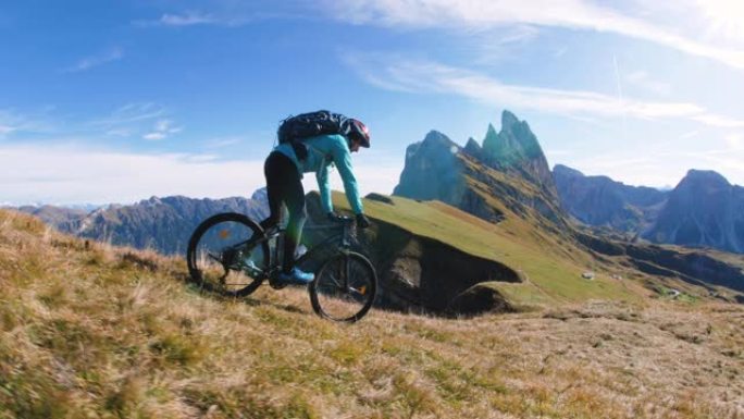 日出时骑着山地自行车的年轻人在塞塞达山顶骑自行车。Puez Odle，特伦蒂诺，多洛米蒂，意大利。