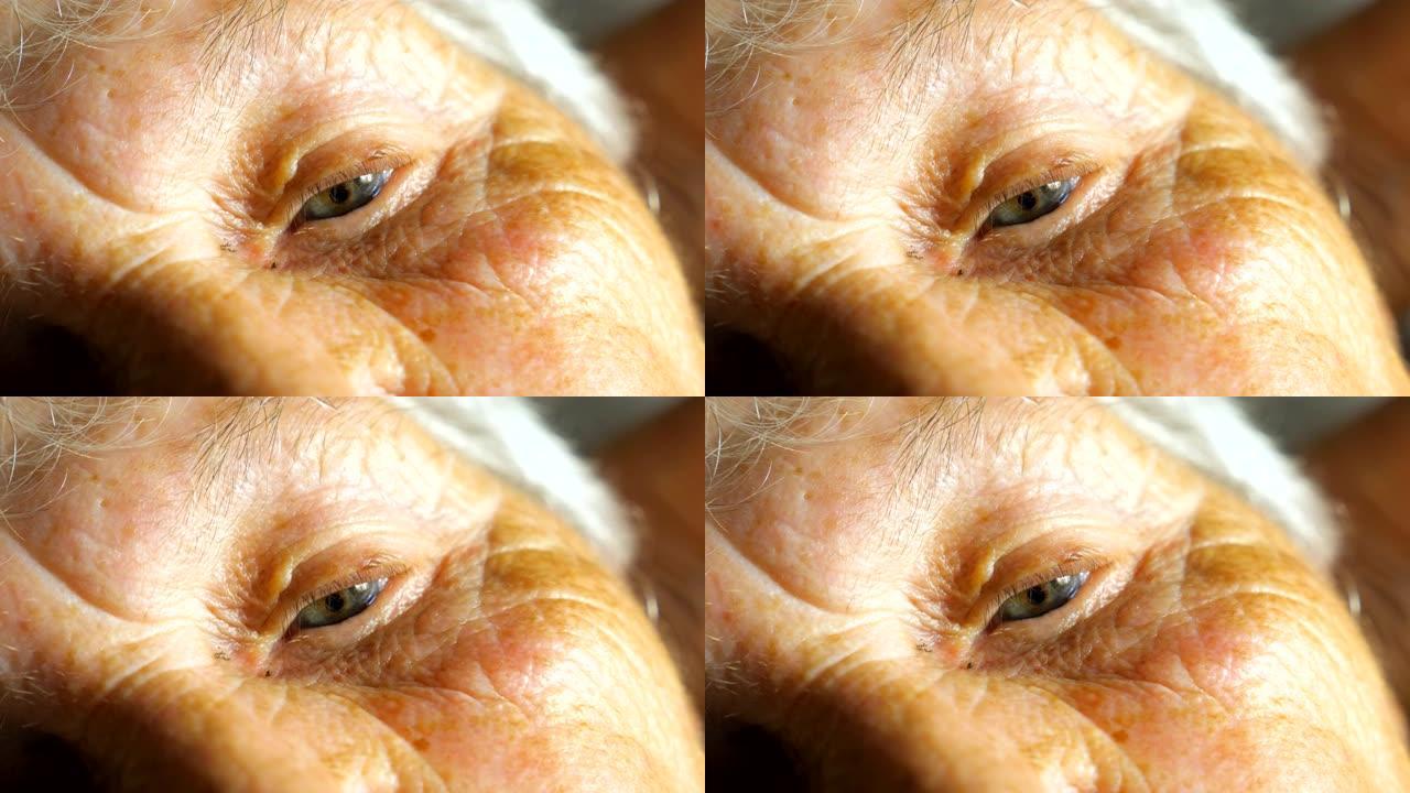 老年妇女看着沉思的肖像。关闭周围有皱纹的老女性眼睛。慢动作细节视图