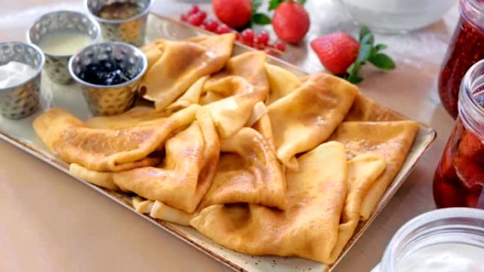 俄罗斯传统煎饼，blini配果酱，酸奶油和草莓。特写视图。