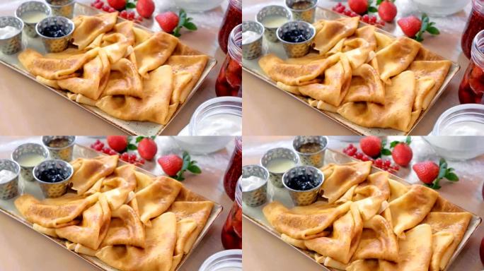 俄罗斯传统煎饼，blini配果酱，酸奶油和草莓。特写视图。