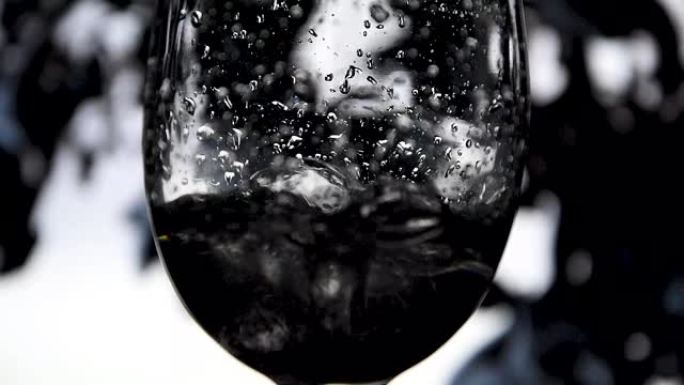 在彩色背景上将白葡萄酒从瓶中倒入高脚杯的慢动作，用于葡萄酒广告的精美素材