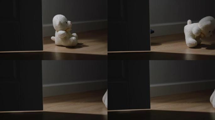 小毛绒熊玩具被踢进黑暗的空房间，门关上
