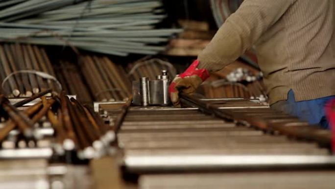 使用滚筒机机床的手套工人专家。用于金属钢筋弯曲的工业弯管机。选择性聚焦。