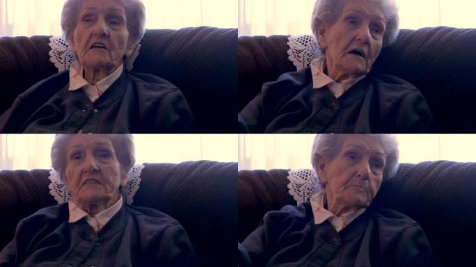 坐在沙发上的一位老妇人一边说话一边用手指指点点