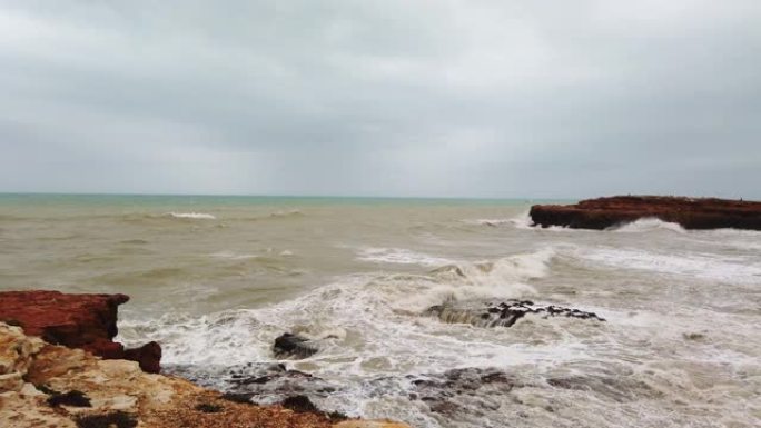 暴风雨来临前，海浪正冲入一个岛屿的岩石悬崖。4k