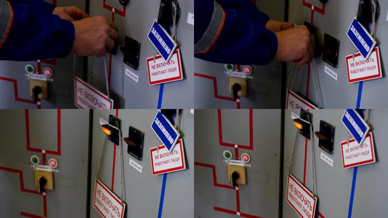 电工在配电盘门上挂起警告标志