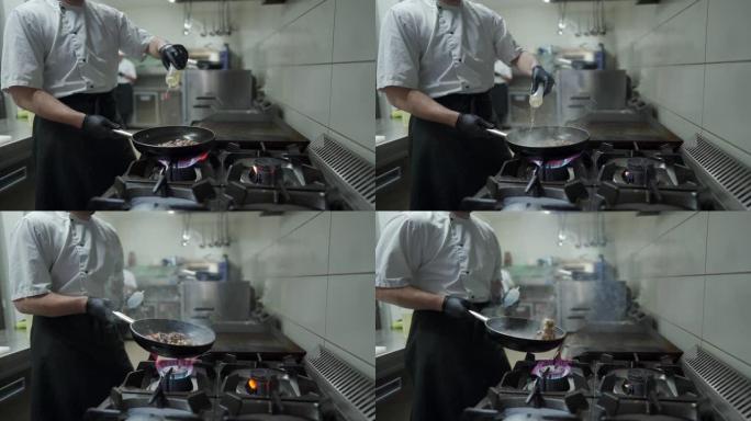 厨师在厨房的煎锅上准备饭菜