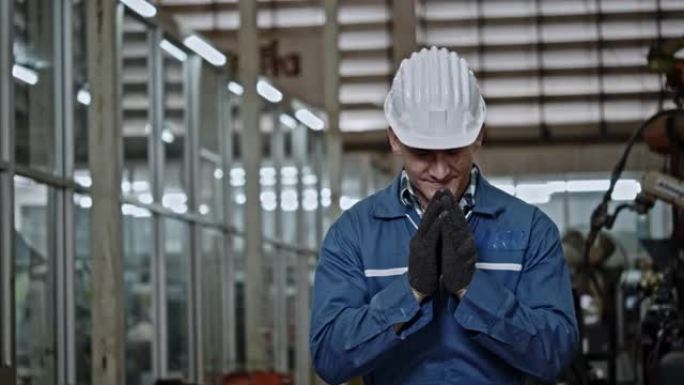 工厂人用手打招呼，以工作愉快的微笑表示敬意。安全帽有助于机械师工作期间的安全。非接触式问候语有助于防
