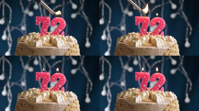 蓝色背景上有72号粉色蜡烛的生日蛋糕。蜡烛着火了。慢动作和特写视图