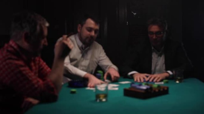 资深男子在黑暗的房间里赢得扑克手