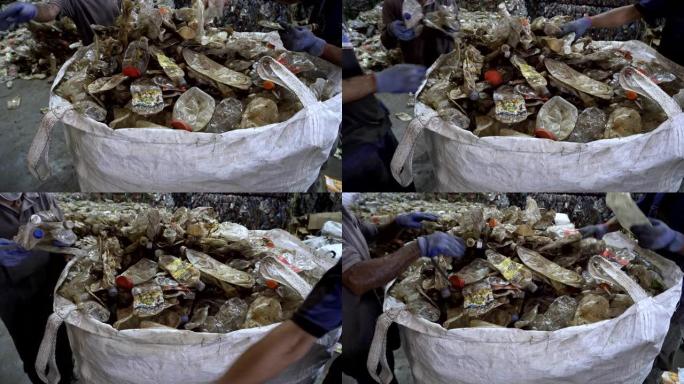 身份不明的工人选择压碎的透明塑料瓶在回收中心进行加工。