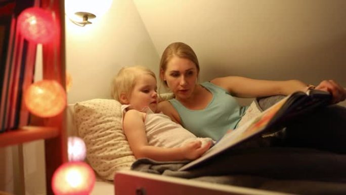 mother and daughter reading fairy book together in