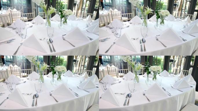 婚礼餐桌摆放着鲜花和餐具，供客人使用。