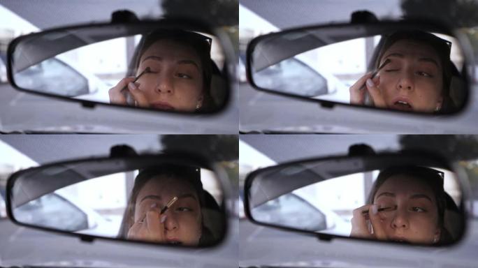 一个美丽的白人女孩看着汽车的后视镜，把她的眼睛上的阴影。17、违章在车里。一个女人聚集在交通工具上