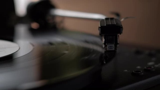 转盘。手打开古董电唱机。乙烯基唱片纺纱。老式转盘上的针演奏唱片专辑的宽镜头特写。