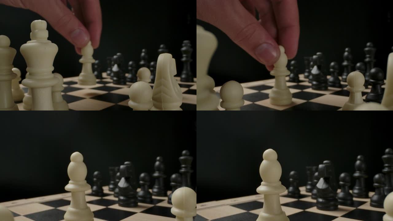 男子的手从第一行移动白色主教棋子