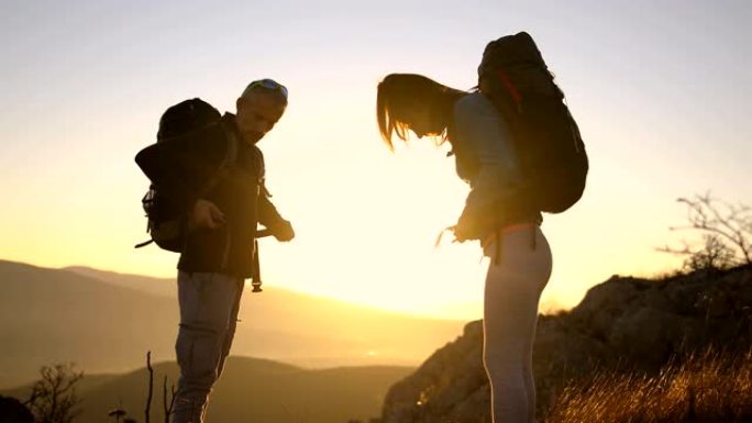 幸福的年轻夫妇收拾背包在阿尔卑斯山远足。水瓶
