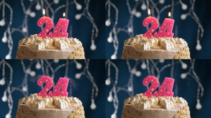 蓝色背景上有24号粉色蜡烛的生日蛋糕。蜡烛吹灭了。慢动作和特写视图