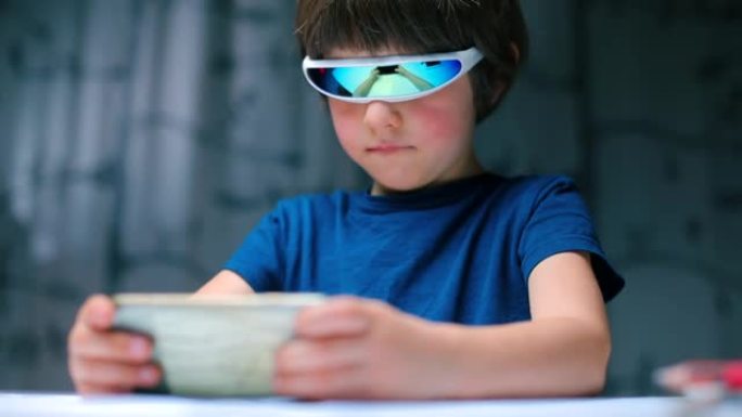 儿童戴着特殊眼镜在手机上玩电子游戏的肖像。