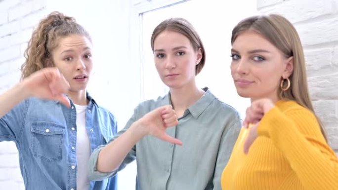 失望的女性创意团队表现出大拇指