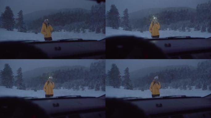 汽车视点。在雪地里开车。汽车在路上行驶。恶劣天气下偏僻的汽车问题。汽车保险。路上有一个女人。