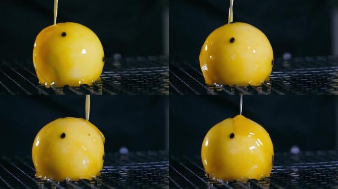 慢动作在球形甜点上倒黄色玻璃的特写镜头。