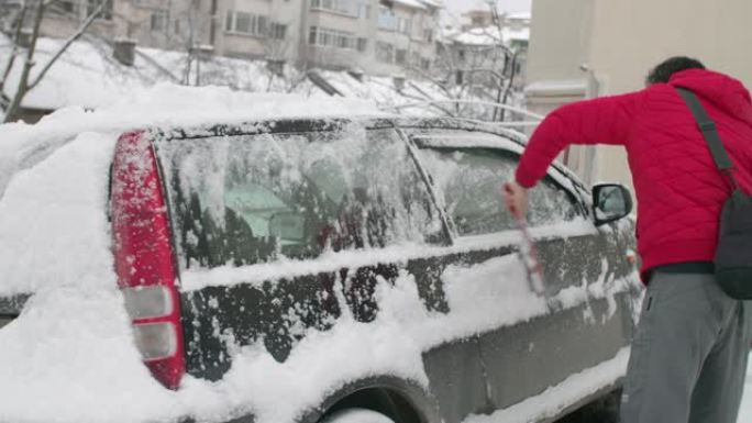 在雪地里开车。成熟的人在第一场雪后清洗汽车。活跃的老年人。