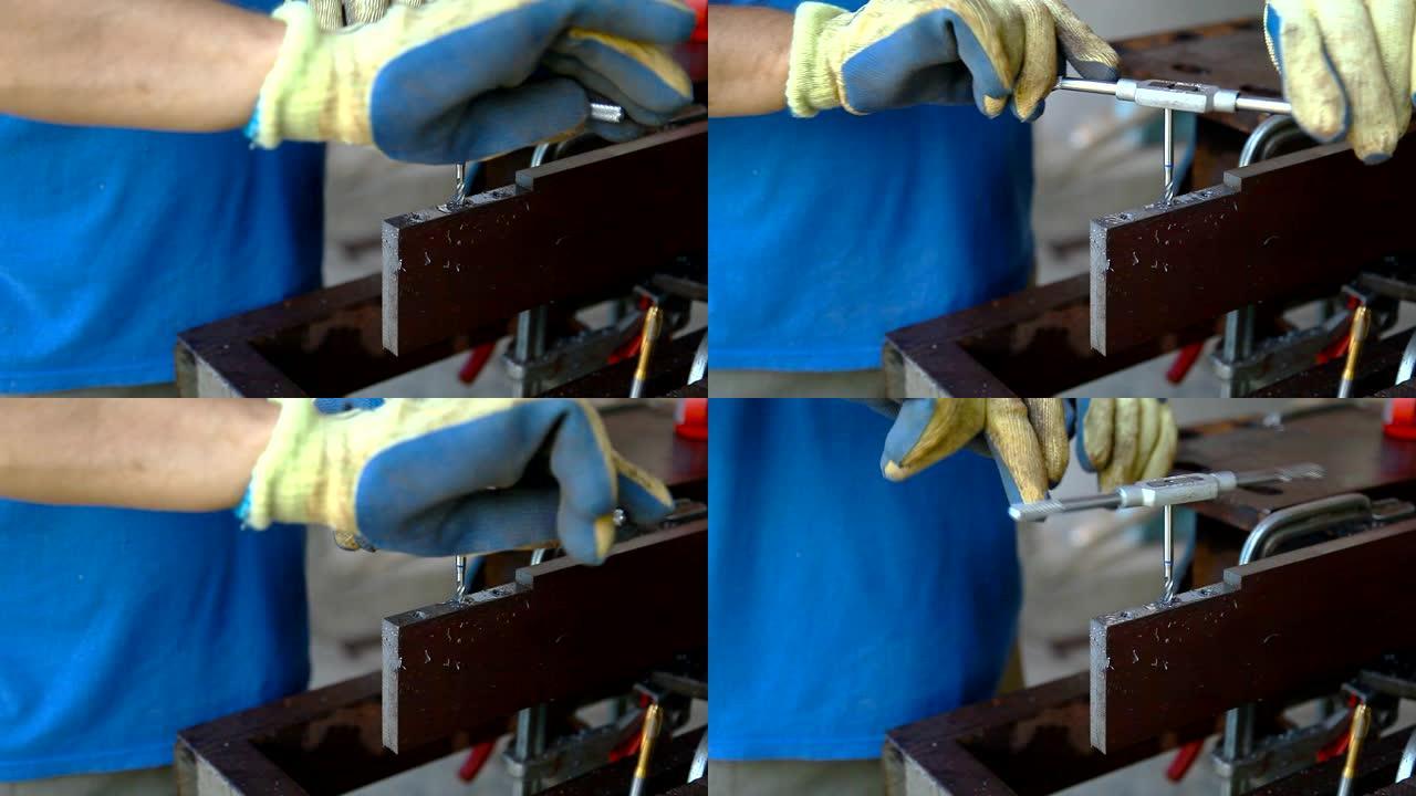 一名戴着防护手套的男子在金属上剪了一根线，以备将来连接。