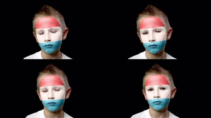 卢森堡足球队的悲伤球迷。一个脸上涂着民族色彩的孩子。