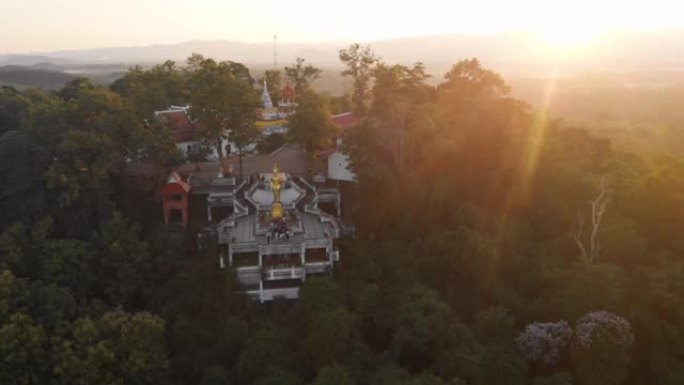 4k无人驾驶飞机向山顶上的泰国佛教寺庙塔下降，佛像，亚洲旅行之旅，相信冥想，日落黄金时刻，平静祥和，